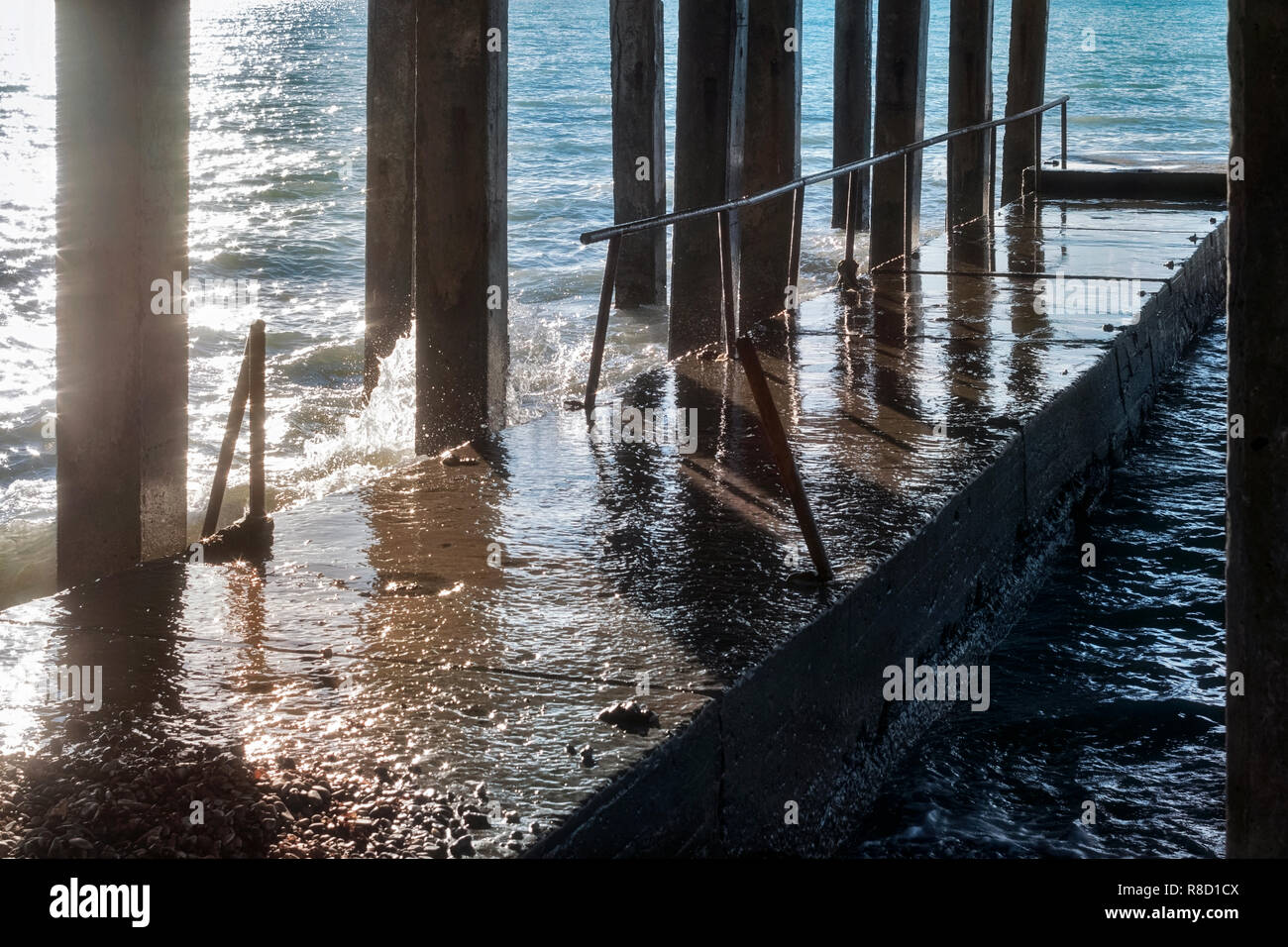 Diga in calcestruzzo con calcestruzzo colonne durante una tempesta nel giorno di sole sulla costa del mare Foto Stock
