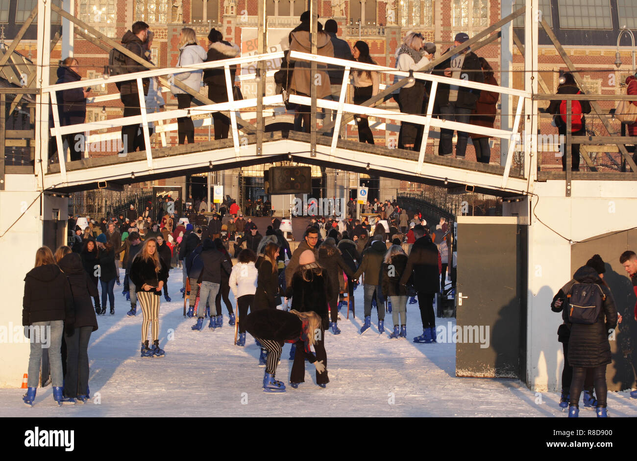 Persone pattinaggio e godendo sulla pista di pattinaggio su ghiaccio in Piazza Museo sul dicembre 14, 2108 a Amsterdam, Paesi Bassi. Dopo diversi giorni di pioggia blustery, Foto Stock