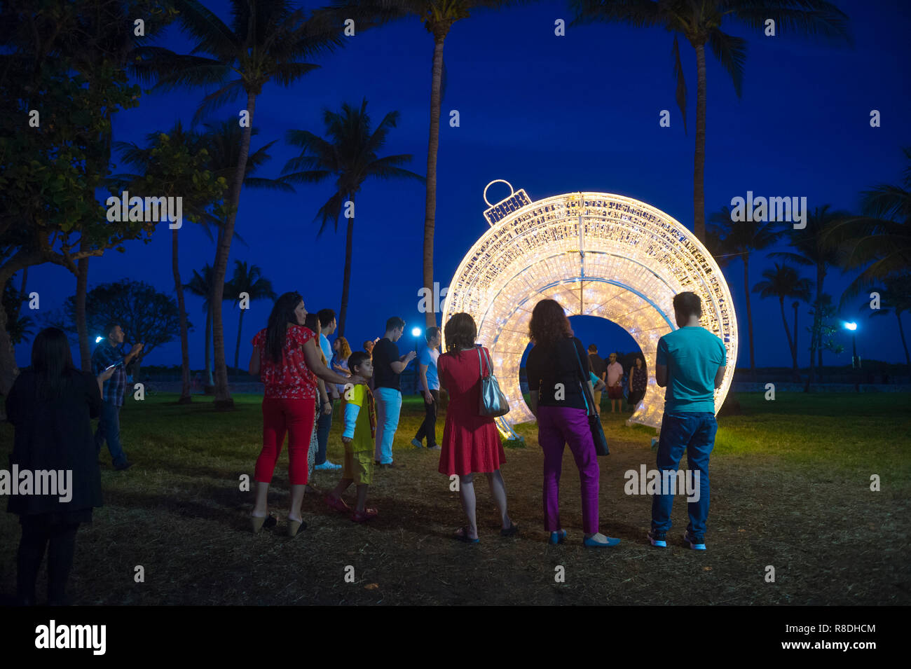 MIAMI - Dicembre 2017: i visitatori si radunano per scattare foto di fronte a un gigante illuminato ornamento di Natale impostato nelle palme di Lummus Park. Foto Stock