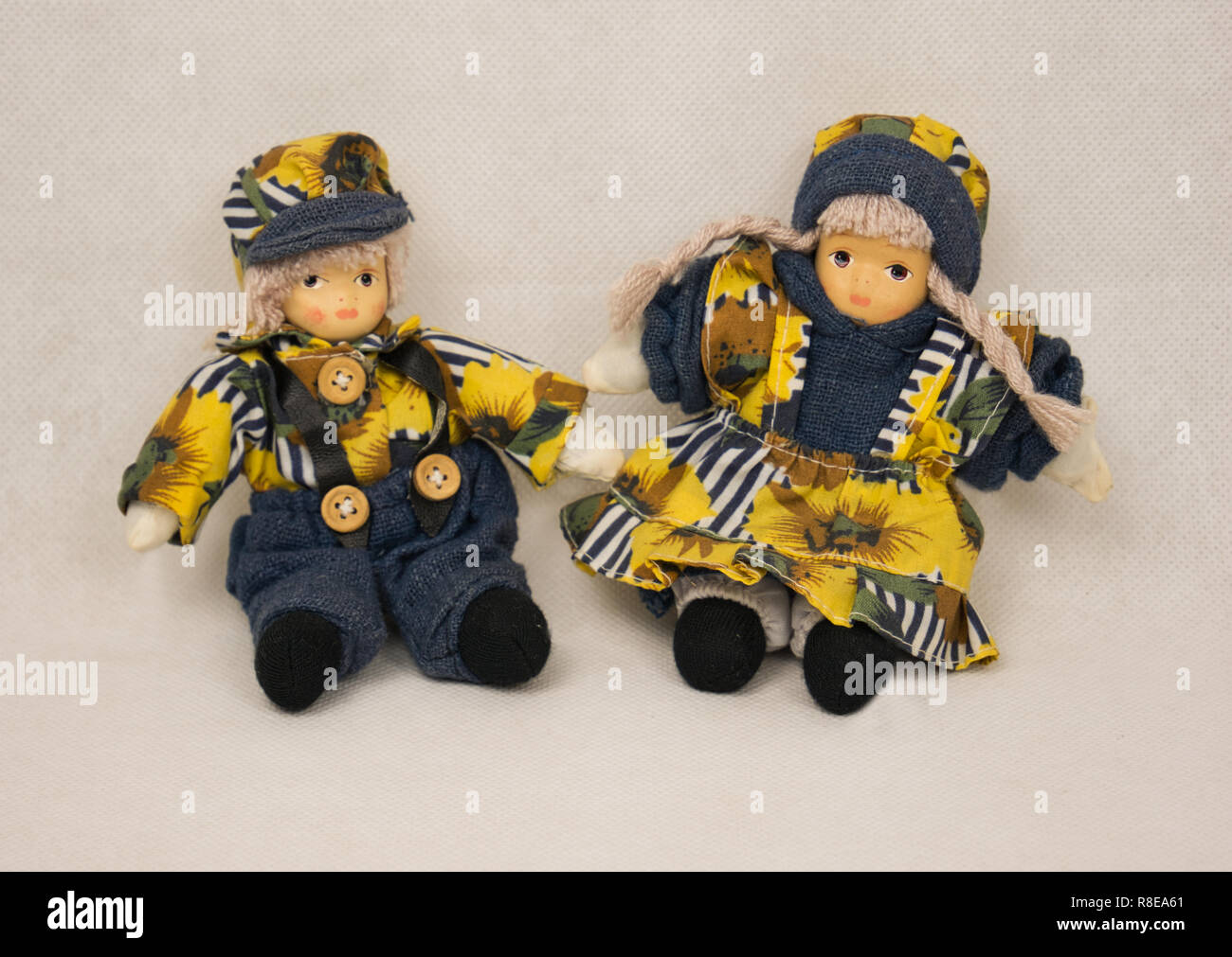 Due piccole bambole con giallo blu vestiti e un cappuccio Foto Stock