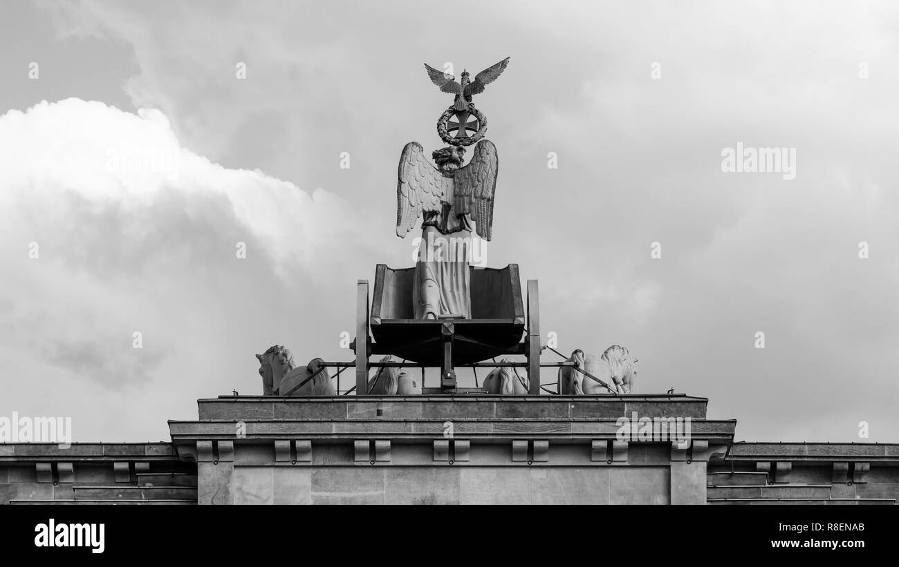 La Quadriga della Porta di Brandeburgo contro un blu cielo nuvoloso di Berlino in Germania, in bianco e nero Foto Stock