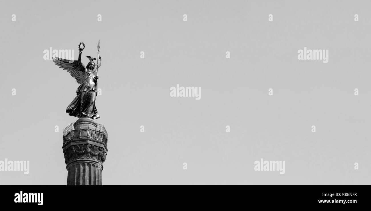 La statua dorata di Victoria sulla parte superiore della colonna della vittoria di Berlino in Germania contro un cielo blu con copia spazio, in bianco e nero Foto Stock