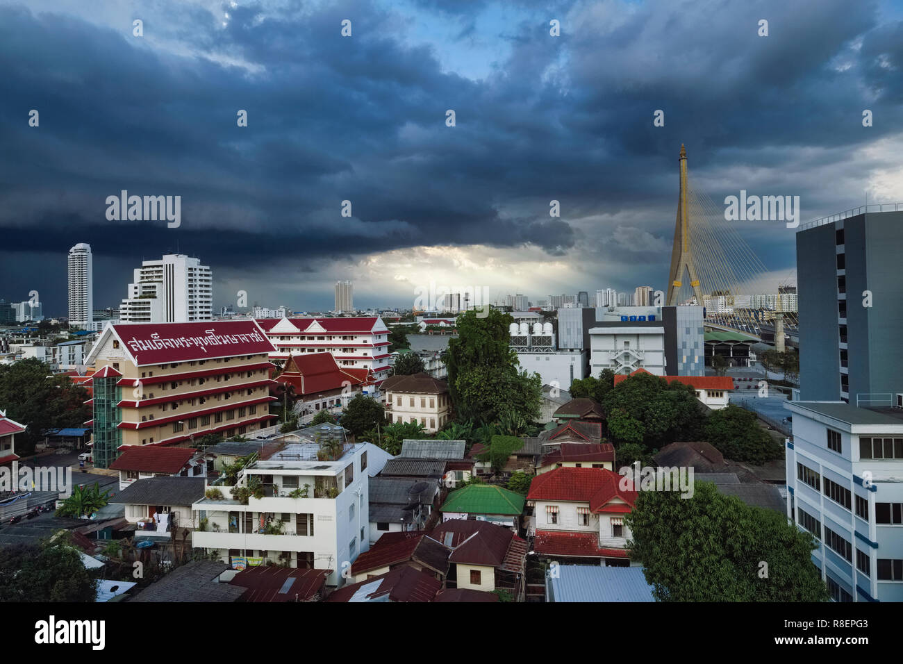 Monsoon scure nuvole sopra Rama XIII. Ponte (a destra) e Wat Sam Phraya (sinistra) nel Phra Nakhon area di Bangkok, Thailandia Foto Stock