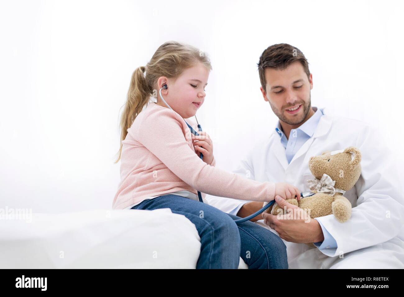 Ragazza che gioca con Teddy bear e stetoscopio. Foto Stock