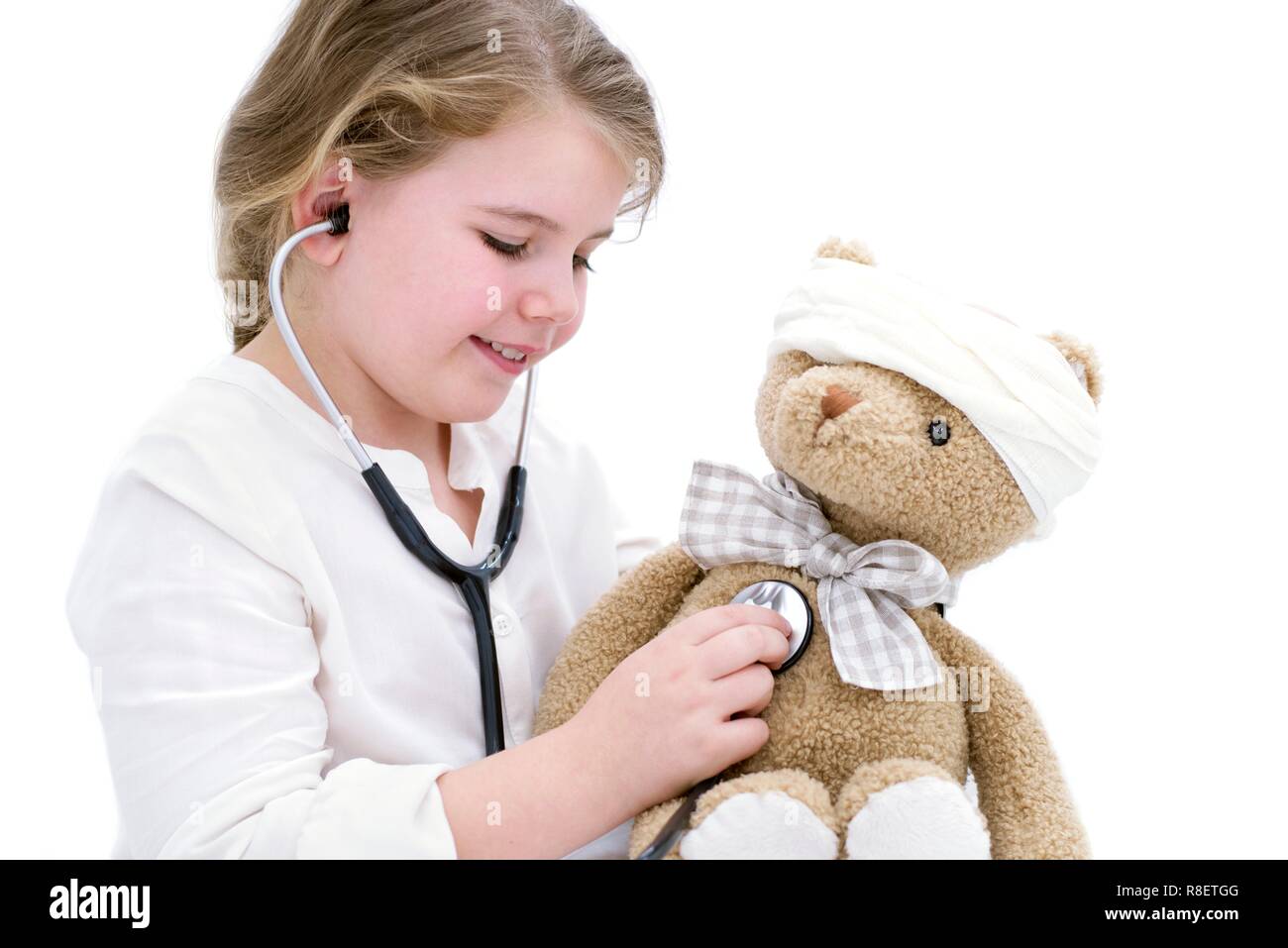 Giovane ragazza che gioca con Teddy bear e stetoscopio. Foto Stock