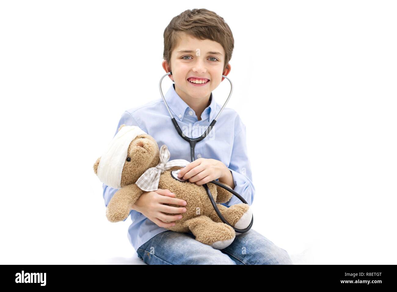 Ragazzo giocando con Teddy bear e stetoscopio. Foto Stock