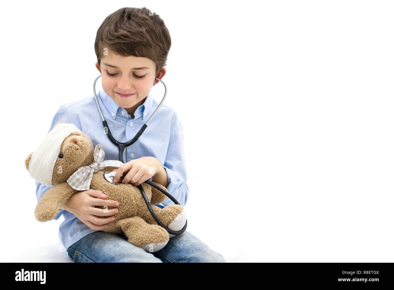 Ragazzo giochi di ruolo con Teddy bear e stetoscopio. Foto Stock