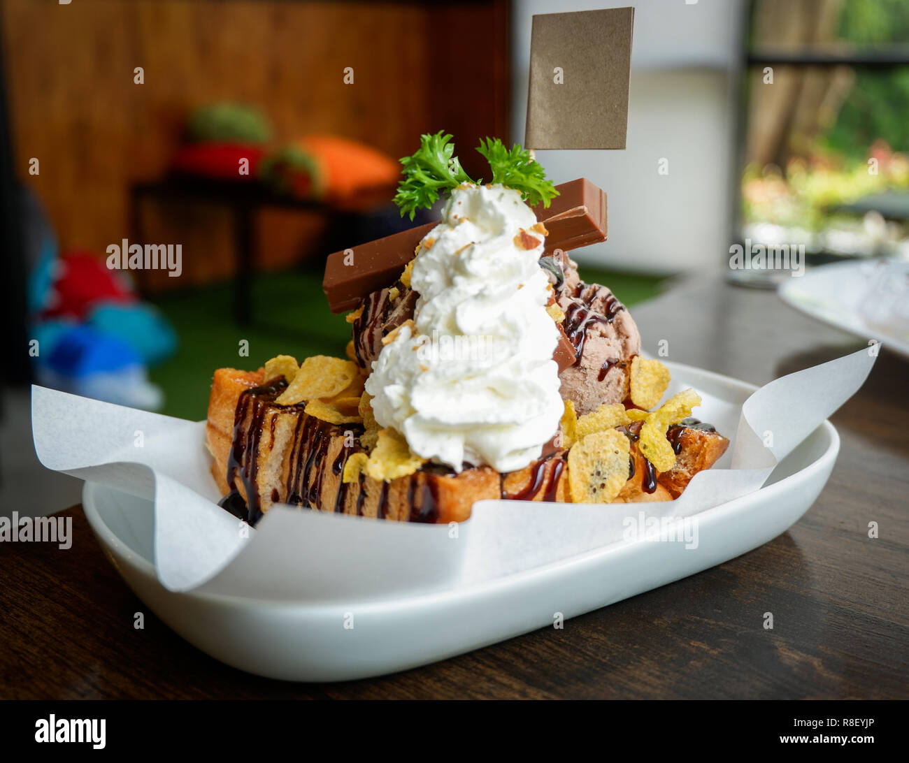 Il miele santos gelato dessert / pane con gelato al cioccolato palline di corn flake montare la panna barra di cioccolato e miele delle api su piastra bianca in cafe co Foto Stock