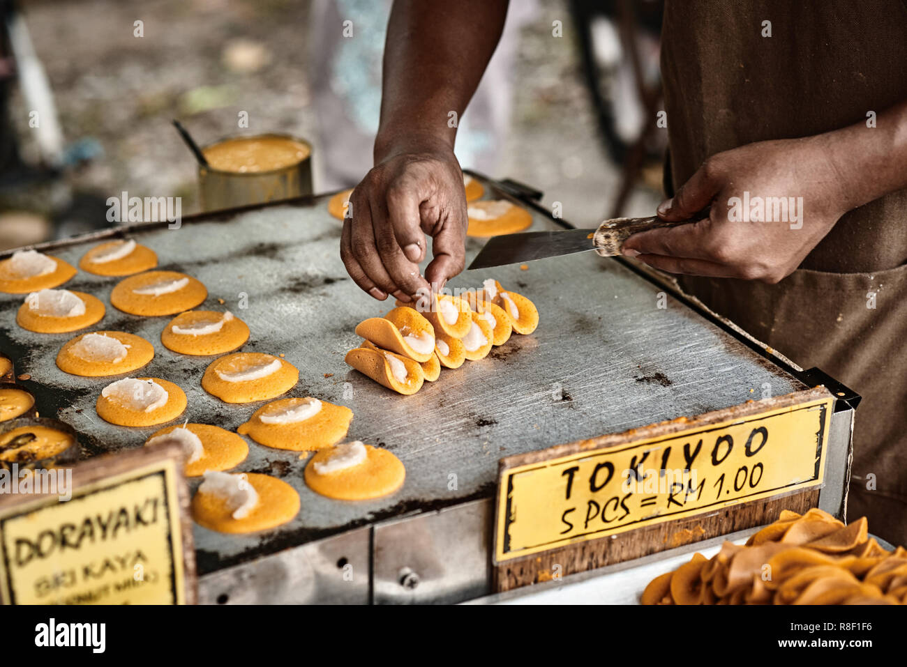 La cottura di Tokiyoo, tradizionali asiatici frittelle dolci con noce di cocco che riempie l'interno. Classica asiatica cucina di strada da l'isola di Langkawi in Malaysia. Foto Stock