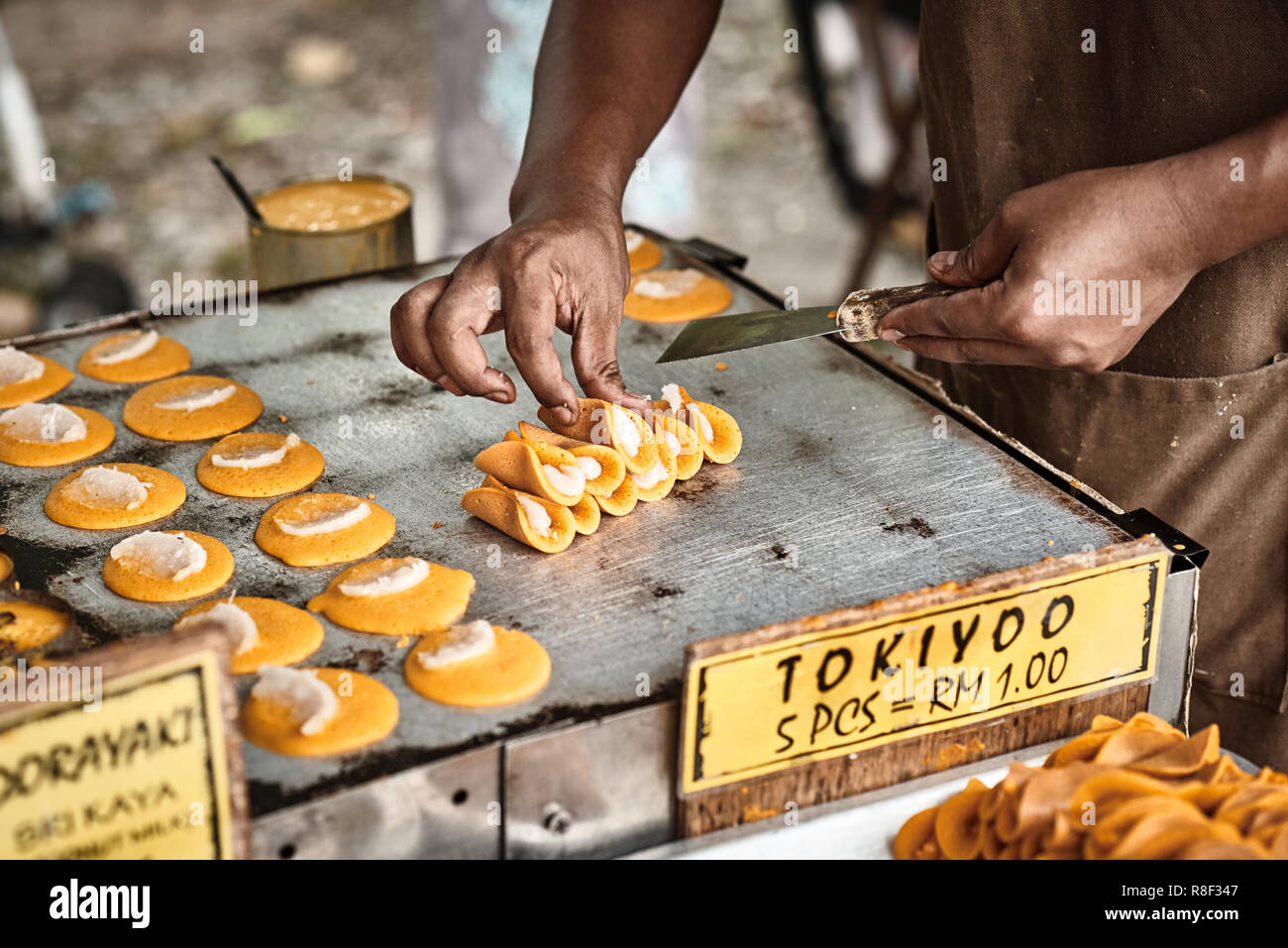 La cottura di Tokiyoo, tradizionali asiatici frittelle dolci con noce di cocco che riempie l'interno. Classica asiatica cucina di strada da l'isola di Langkawi in Malaysia. Foto Stock