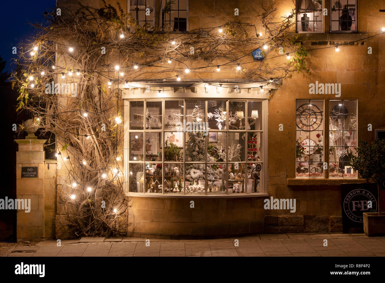 Pavilion Broadway shop natale nella finestra di visualizzazione di notte. Broadway, Cotswolds, Worcestershire, Inghilterra Foto Stock