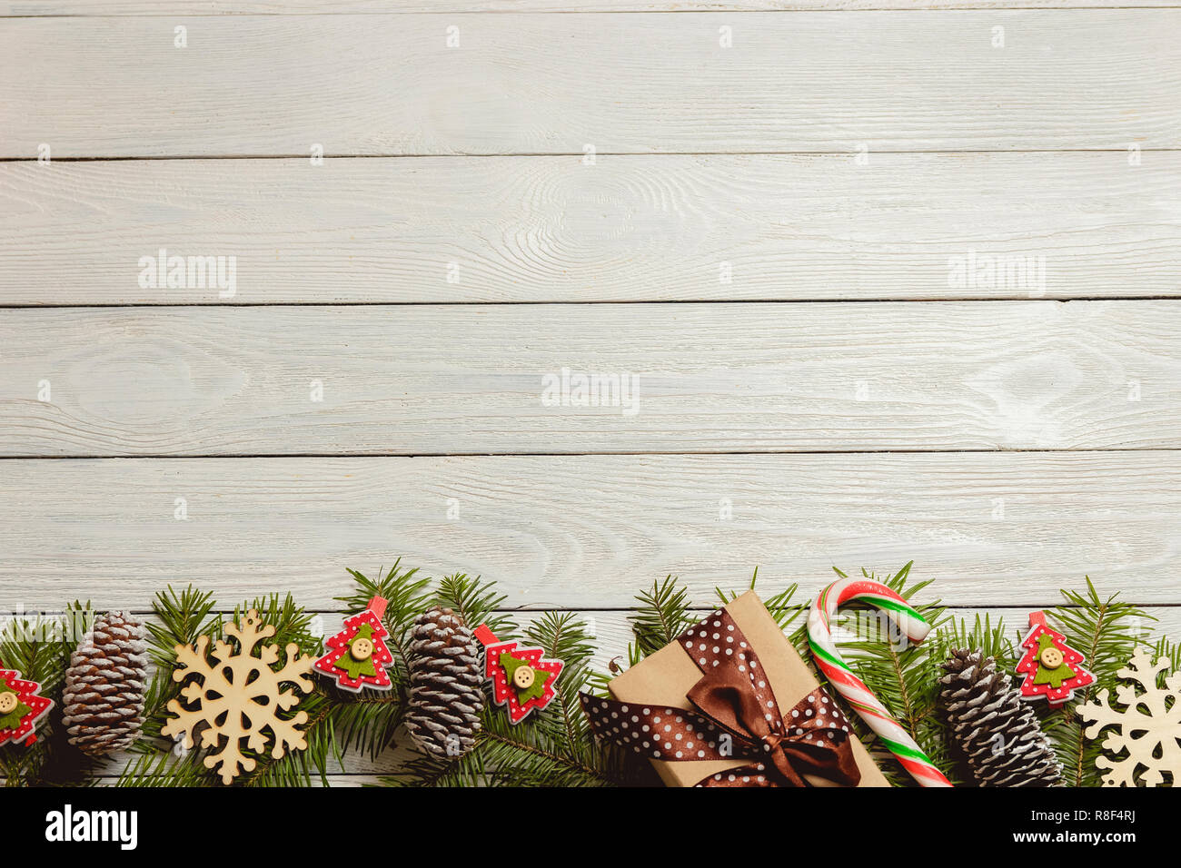 Legno bianco sullo sfondo di Natale con rami di abete, coni, arredamento, vista dall'alto, copyspace Foto Stock