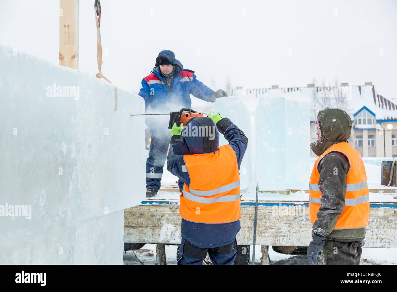 Lavoratori costruire una città di ghiaccio da blocchi di ghiaccio per le vacanze di Natale Foto Stock