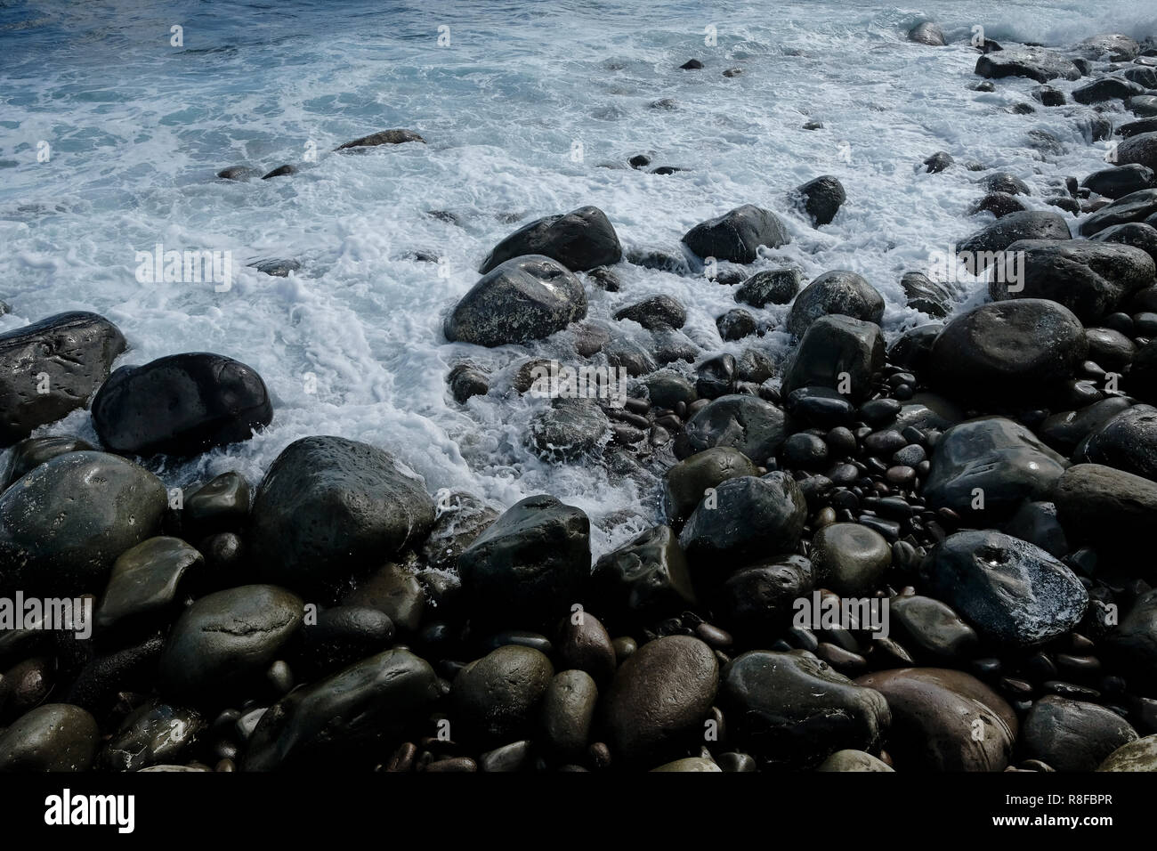 Tratto di massi lucidato e rotondeggianti rocce lungo il Boulder Valugan Beach localmente noto come Chanpan beach ha detto di aver realizzato dall'eruzione del Mt. Iraya nel 400 d.c. e migliora nel tempo dalle onde hurdled implacabile dall'Oceano Pacifico sulla sponda orientale del Batán l'isola principale di Batanes il più settentrionale della provincia dell'arcipelago delle Filippine situato nella valle di Cagayan regione Foto Stock