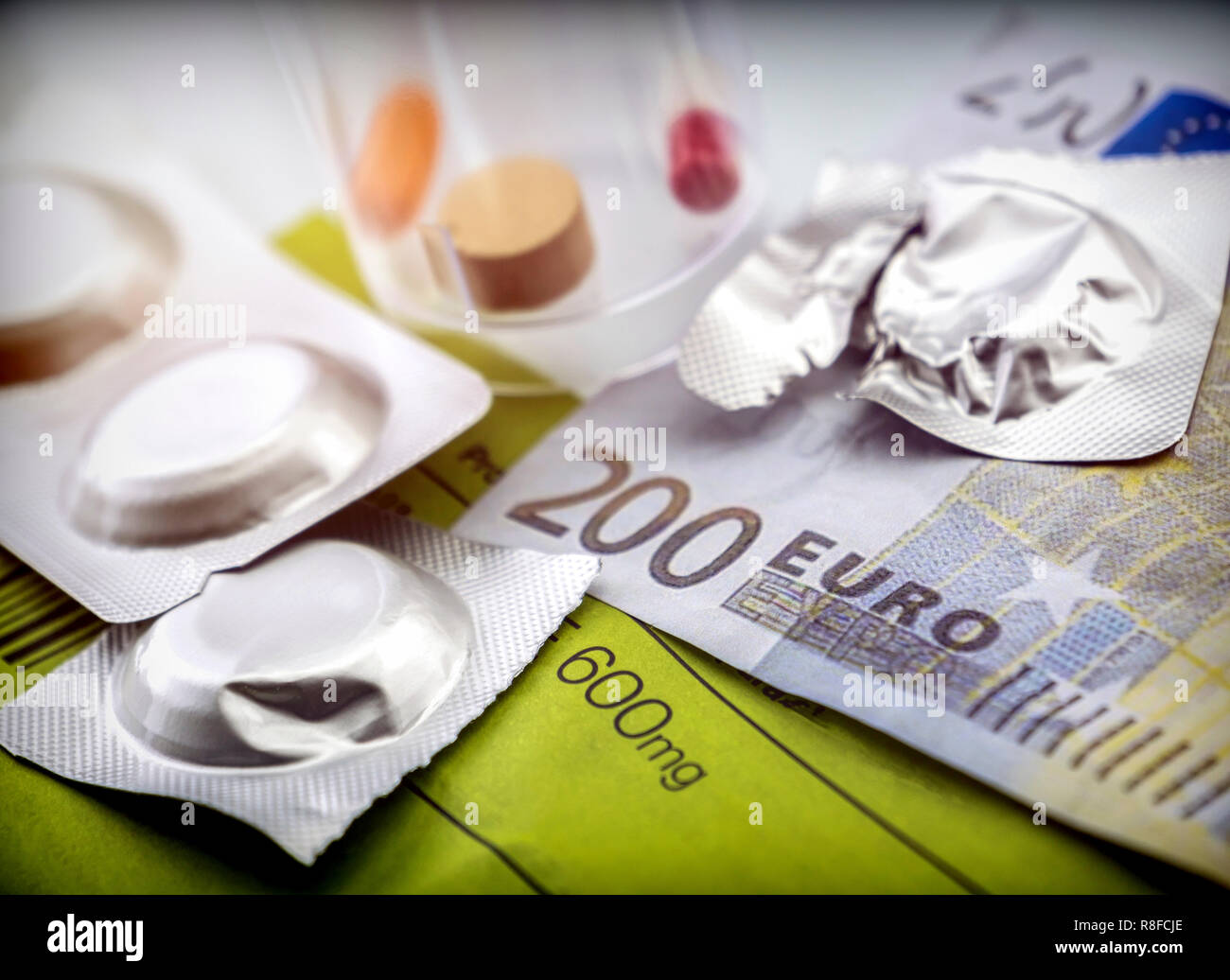 Pastilla effervescenti di accanto al farmaco al giorno su un biglietto di 200 euro, concetto di pagamento congiunto la salute Foto Stock