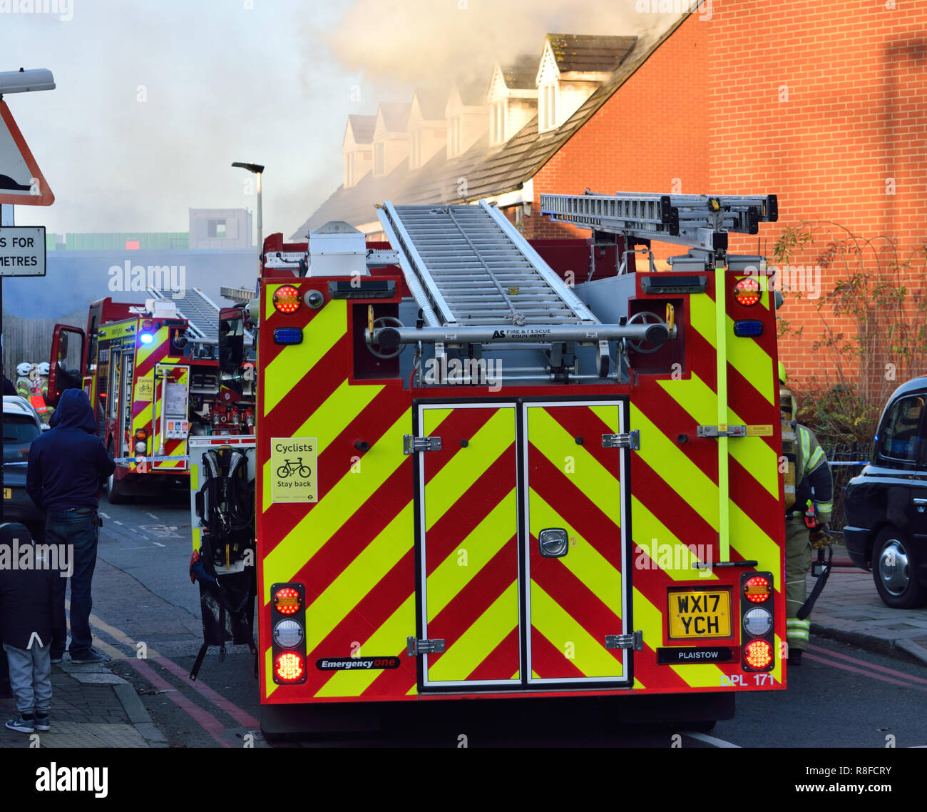 Servizi di emergenza risponde ad una casa di fuoco in una strada residenziale nella zona est di Londra con un certo numero di motori Fire comprendente una piattaforma aerea Foto Stock