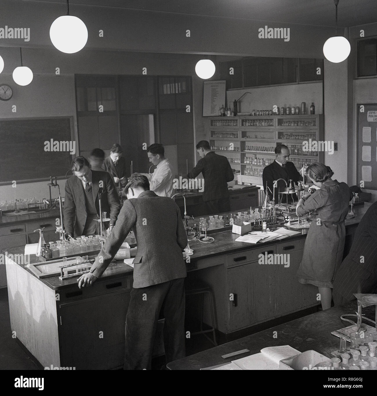 1948, classe scientifica presso il South West Essex Technical College, studenti che conducono esperimenti con bottiglie di sostanze chimiche. Inaugurato nel 1938 a Forest Rd, Walthamstow come uno dei quattro college tecnici regionali dell'Essex, è diventato noto come "Università del popolo", con le più recenti strutture educative, tra cui una sala riunioni da 1200 posti, due palestre, laboratori scientifici e laboratori di ingegneria. Nel 1965, il college fu trasferito dall'Essex County Council al London Borough of Waltham Forest e cambiò il suo nome in Waltham Forest Technical College and School of Art Foto Stock