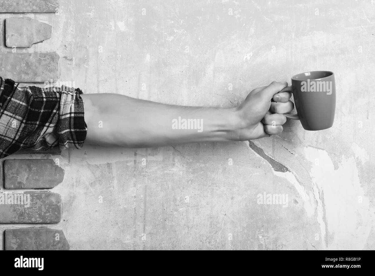 Colore rosa tè o caffè tazza o tazza di ceramica per un drink in man mano sulla trama in ceramica color pastello e un muro di mattoni di sfondo, spazio di copia Foto Stock