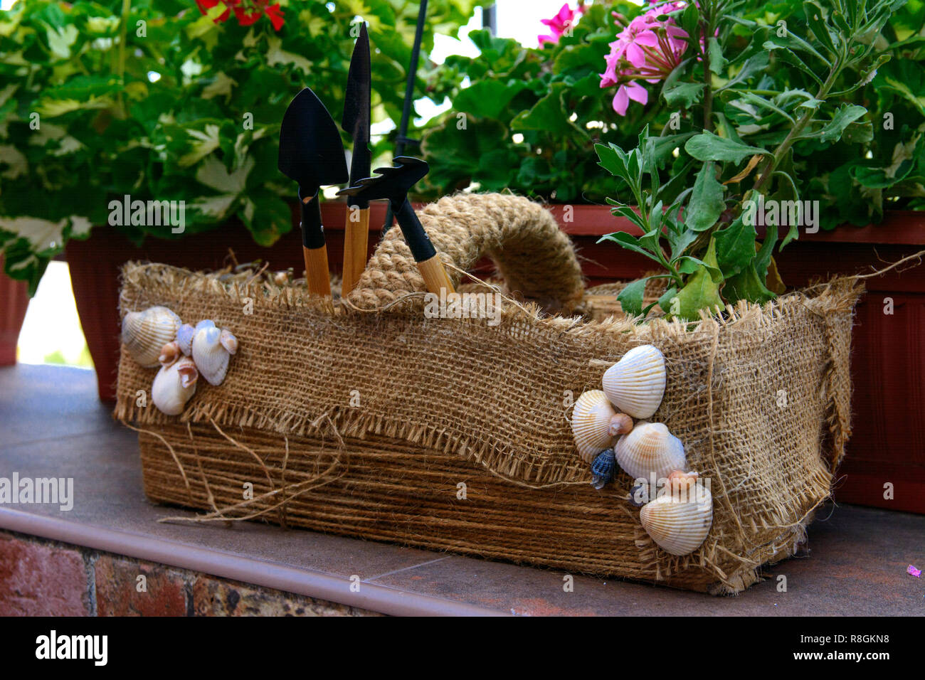Bella, originariamente balcone decorato, con fatti in casa artigianale di vasi per fiori. Pieno di fiori, pentole, altro ornamento. Rosa, verde, bianco. Esempio di progettazione Foto Stock