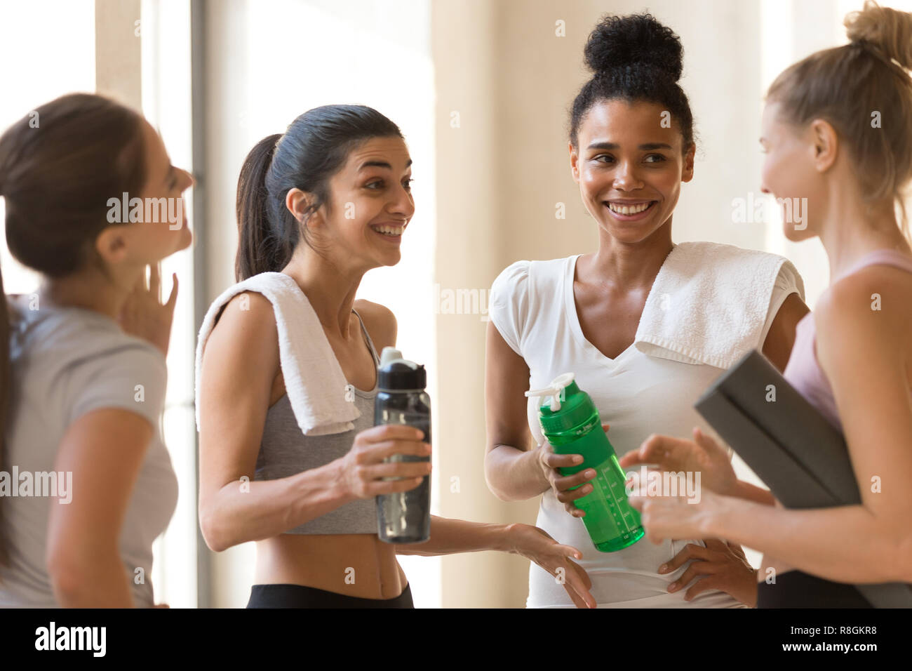 Diversi amici giovani femmine a parlare dopo allenamento Foto Stock