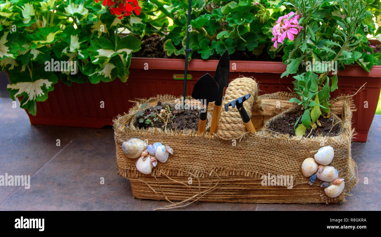 Bella, originariamente balcone decorato, con fatti in casa artigianale di vasi per fiori. Pieno di fiori, pentole, altro ornamento. Rosa, verde, bianco. Esempio di progettazione Foto Stock