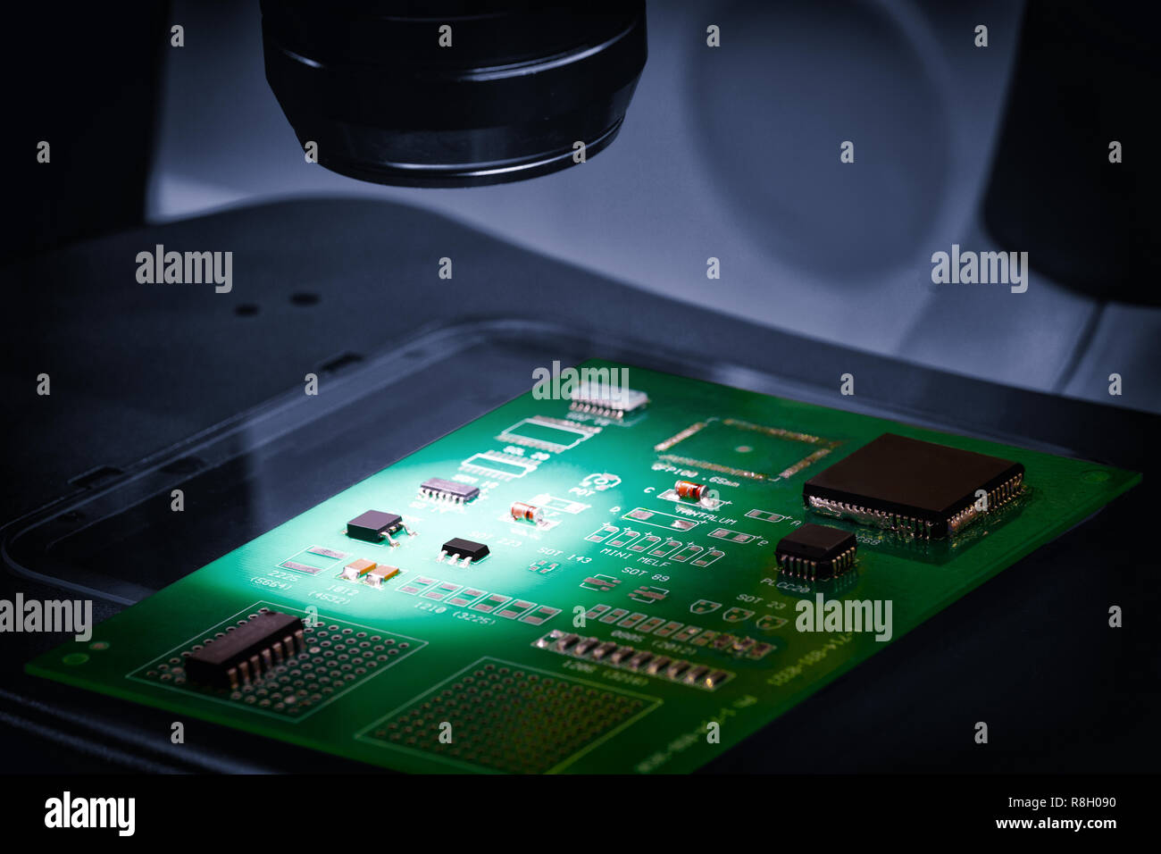 Fabbricazione di chip su una scheda a circuito stampato sotto un microscopio Foto Stock