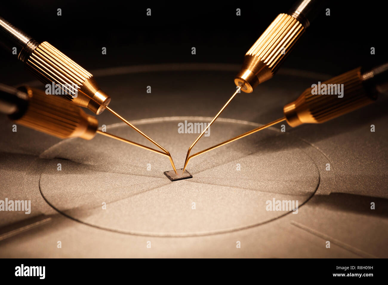 Fabbricazione di chip su una scheda a circuito stampato sotto un microscopio Foto Stock