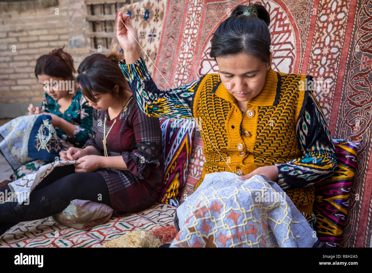 Artigiane rendendo i ricami, officina in Yoqubboy Hoja medressa, Khiva, Uzbekistan Foto Stock