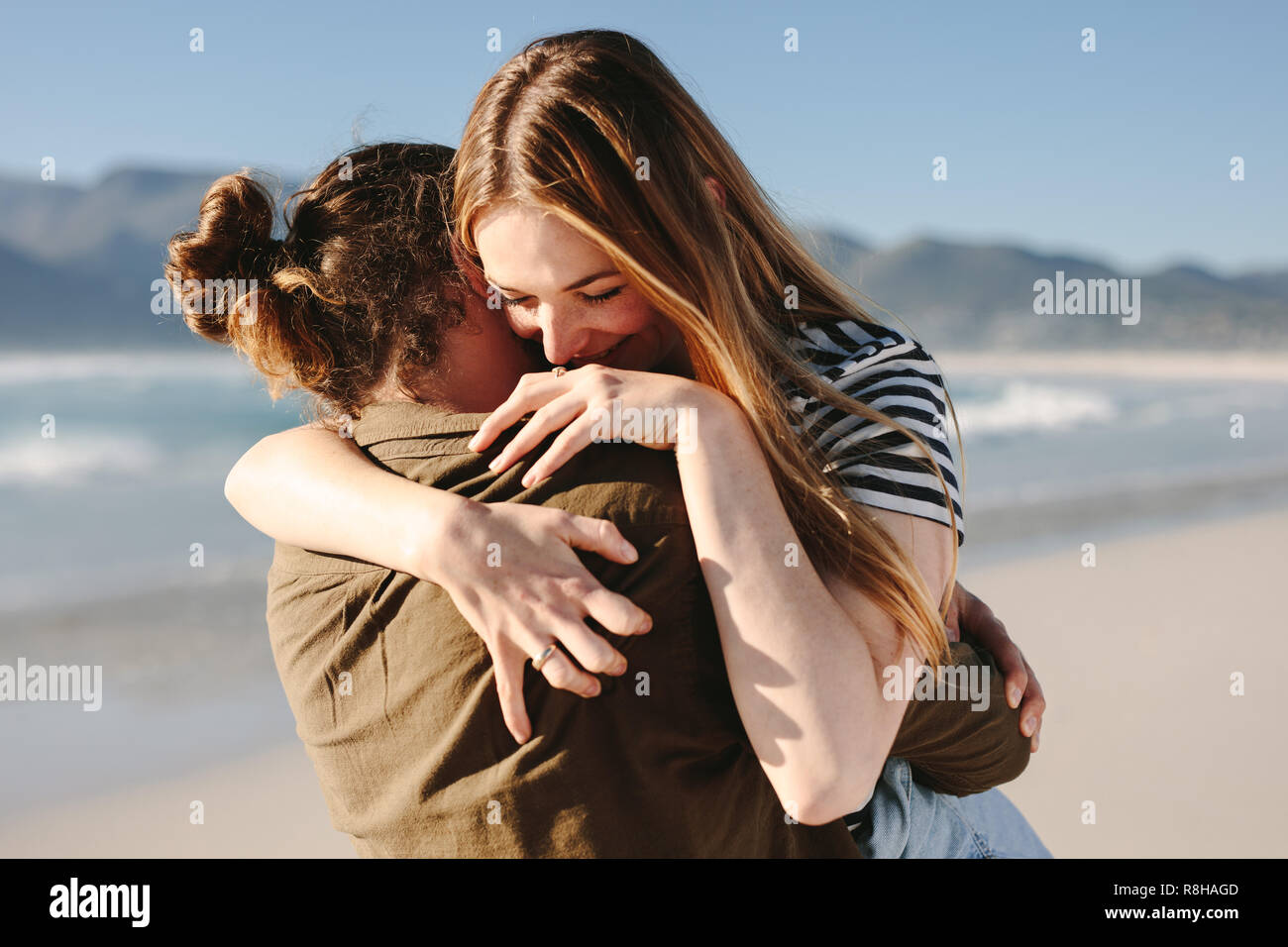 Coppia romantica abbracciando all'aperto sulla spiaggia. Bella donna che abbraccia il suo amore ragazzo sulla spiaggia. Foto Stock