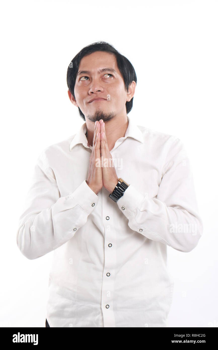 Foto immagine ritratto di un divertente giovane imprenditore asiatico sembrava felice e sorridente mentre pensare e pregare, close up ritratto su bianco Foto Stock