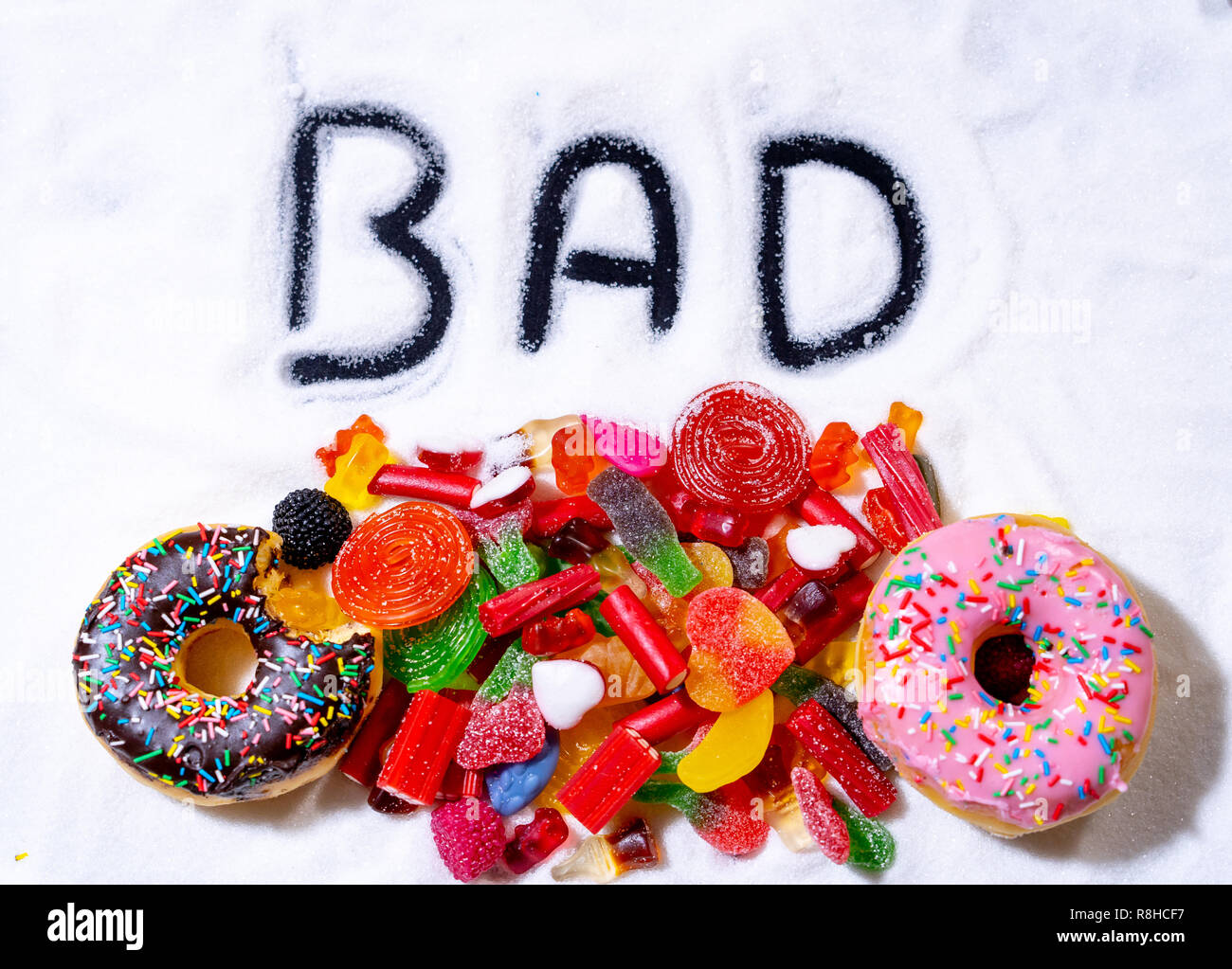 Colorata selezione di dolci caramelle e tratta con la parola scritta male  sullo zucchero bianco in zucchero nella dieta dei bambini provoca problemi  di salute nutrizione Obesit Foto stock - Alamy