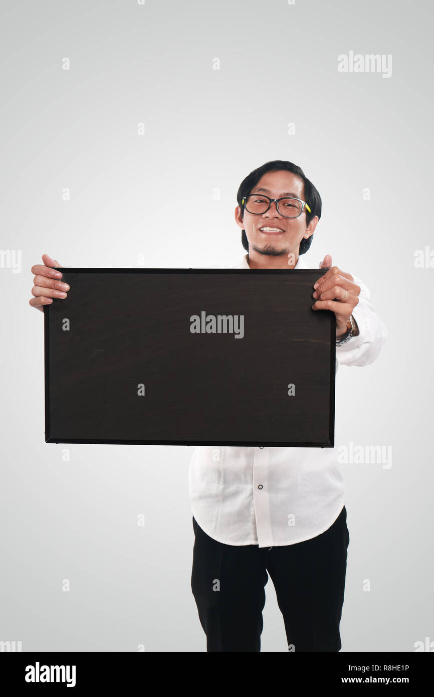 Foto immagine ritratto di funny Asian imprenditore o un insegnante o studente mostrando lavagna vuota con volto sorridente Foto Stock