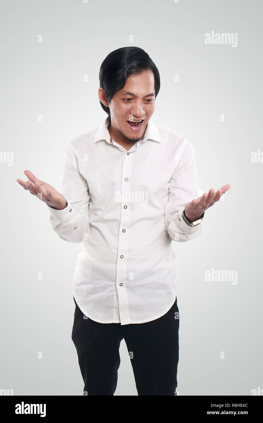 Foto immagine ritratto di un divertente giovane imprenditore asiatici sorridente e mostrando sia del suo palmo aperto e vuoto, guardando da un lato la scelta di concetto Foto Stock