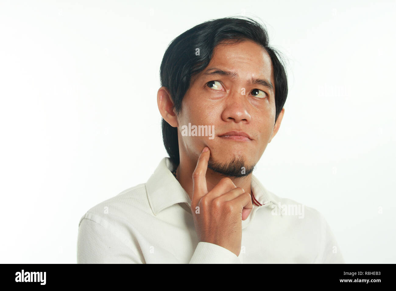 Foto immagine ritratto di un divertente giovane imprenditore asiatici seriamente pensando di qualcosa, close up ritratto su bianco Foto Stock
