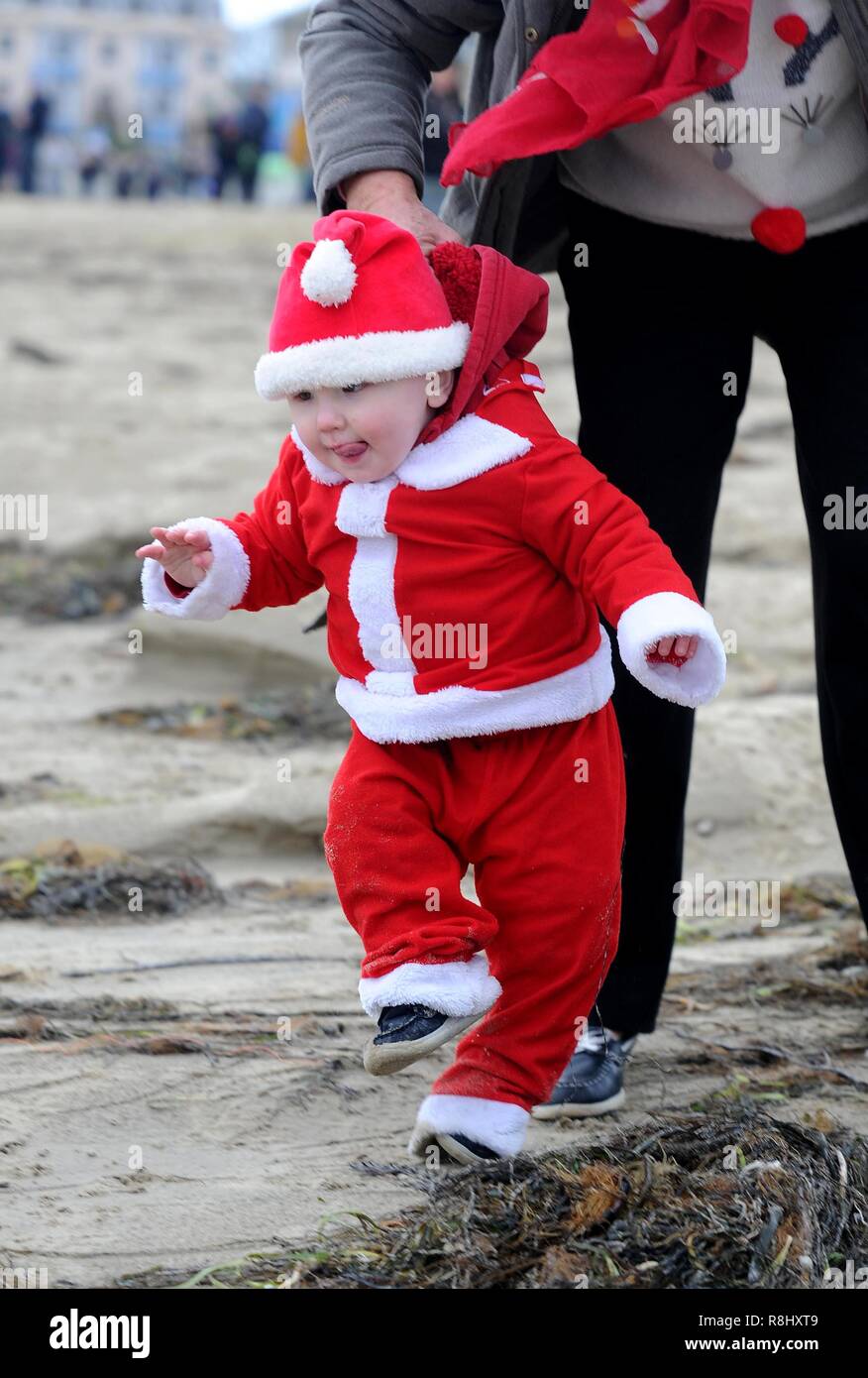 Inseguire il pudding è a 5 km di corsa lungo la spiaggia di Weymouth vestiti da Babbo Natale e a caccia di un budino di Natale e la raccolta di fondi per il popolare di beneficenza locale la volontà Mackaness fiducia. Credito: Finnbarr Webster/Alamy Live News Foto Stock