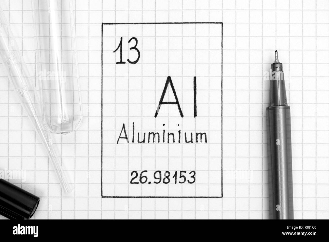 Tavola periodica degli elementi. La grafia elemento chimico di Al in alluminio con la penna nera, tubo di prova e la pipetta. Close-up. Foto Stock