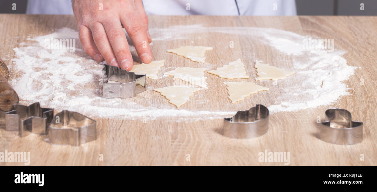 Maschio di cuocere la preparazione di biscotti di Natale, mani close-up Foto Stock