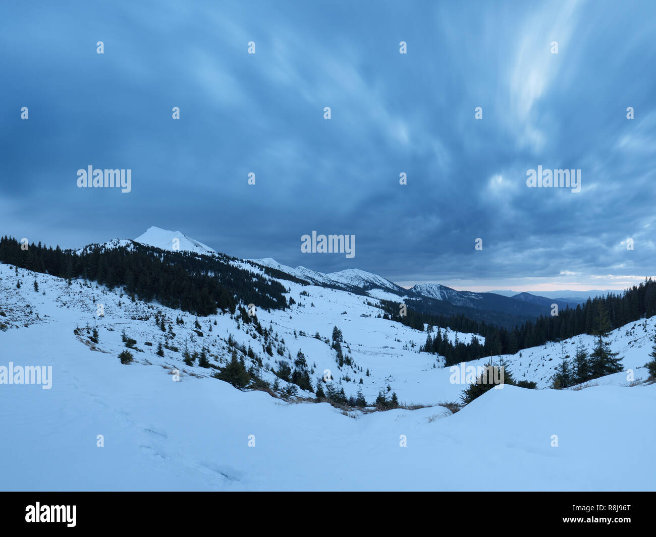 Paesaggio invernale. Crepuscolo serale in montagna. Il cielo di nuvole grigio Foto Stock