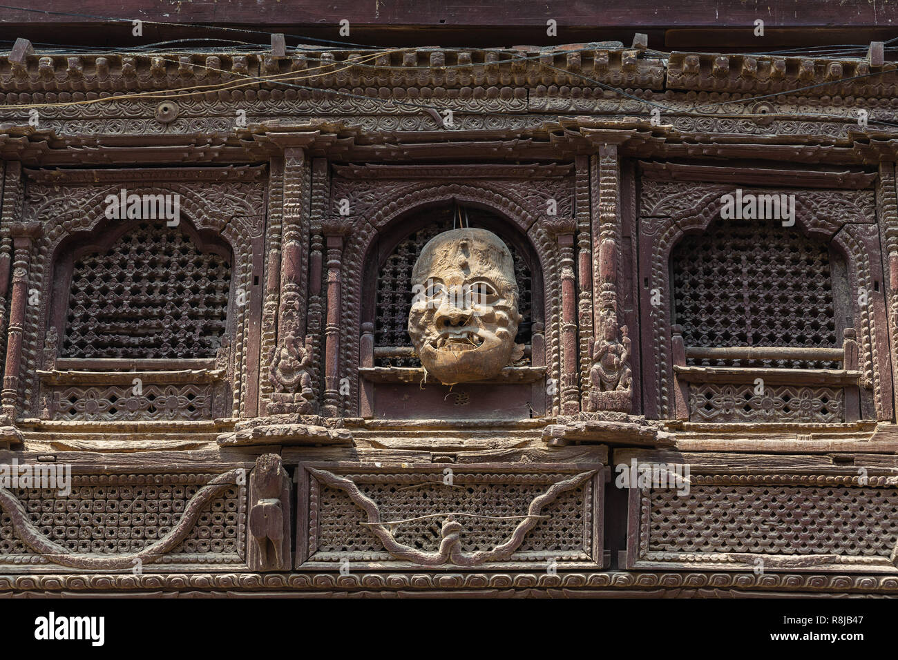 Dettaglio della finestra e la maschera a mano appesa all'esterno dell'edificio in Durbar Square a Kathmandu in Nepal Foto Stock