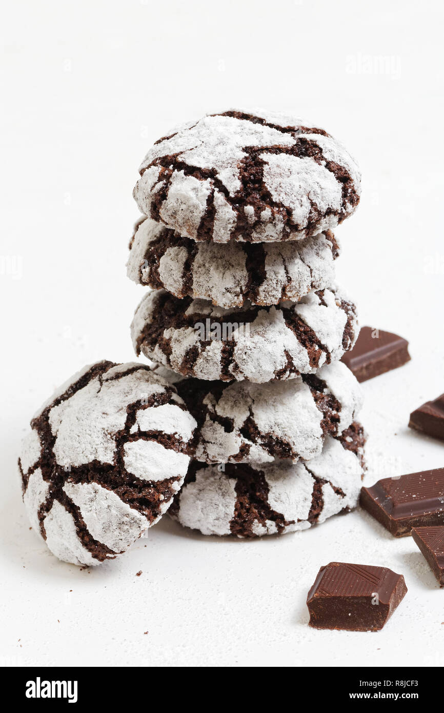 Impilati cioccolato artigianale si increspa i cookie di zucchero in polvere e pezzi di cioccolato su sfondo bianco. Messa a fuoco poco profonde. Foto Stock