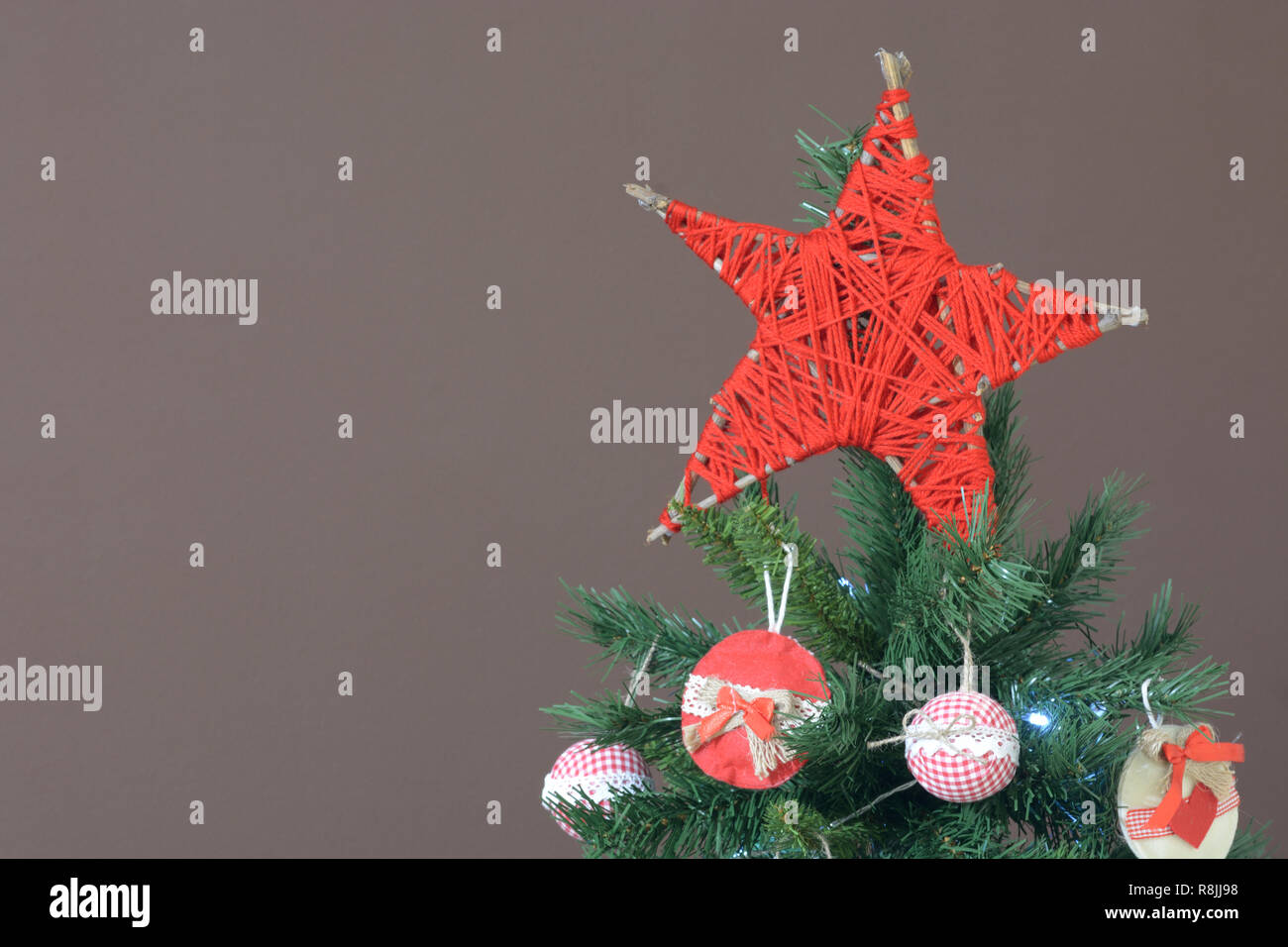 Stella Sull Albero Di Natale.Stella Di Natale Rossa Stella Di Natale Sull Albero Di Natale Sullo Sfondo Di Una Parete Marrone Foto Stock Alamy