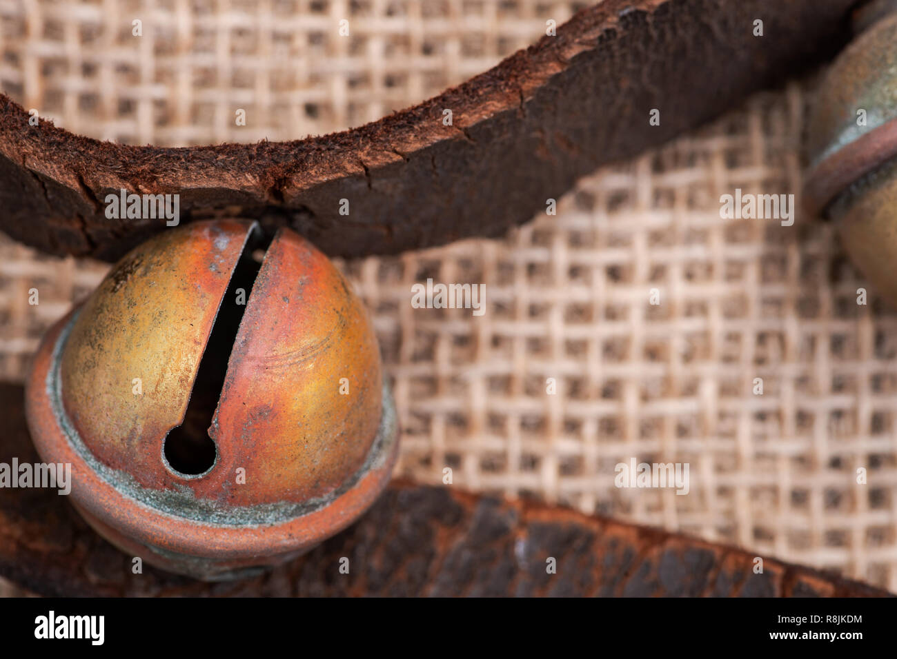 Antique vintage ossidare ottone sleigh bells sul cinturino in pelle e tela sfondo Foto Stock