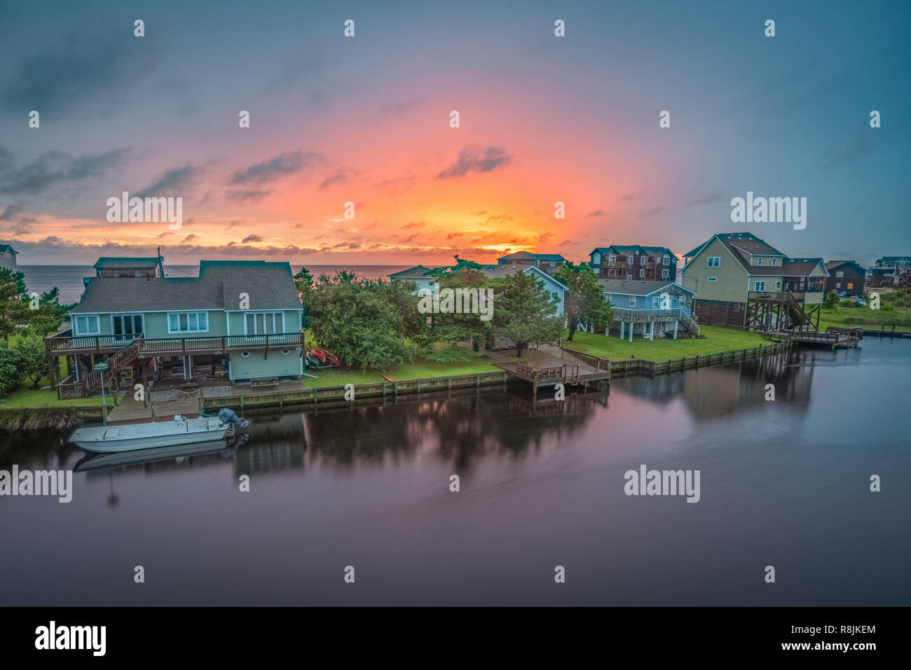 Il sole tramonta dietro una fila di waterfront cottage sui Hatteras Island, NC. Foto Stock