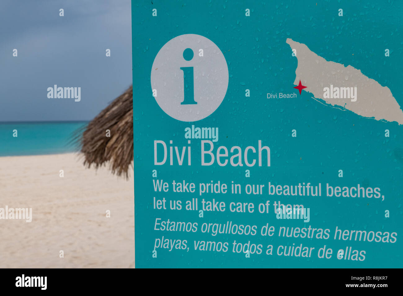 Divi Beach Aruba segno con pioggia nuvole - acquamarina teal e acque turchesi e la spiaggia di sabbia bianca in background Foto Stock
