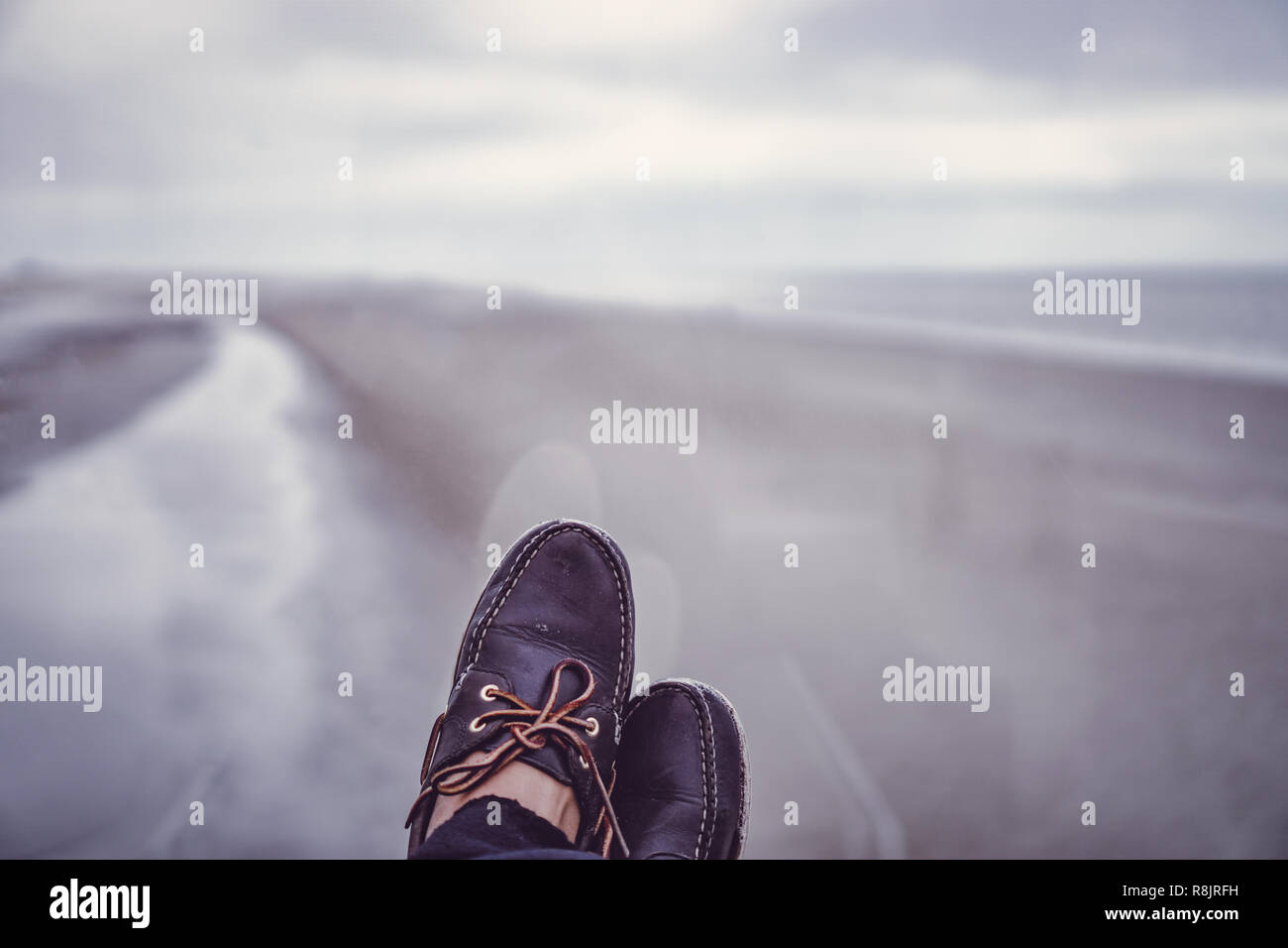 Primo piano della pelle scarpe vela sotto con una splendida vista a mare del Nord spiaggia. Foto Stock