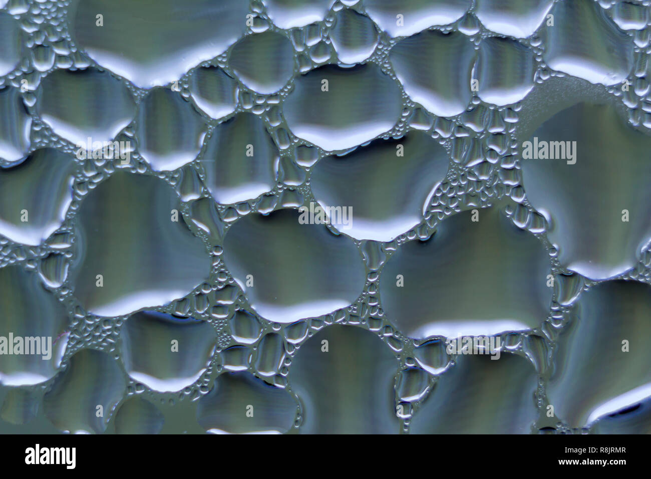 Foto macro. Abstract aqua pattern come sfondo. Immagine di blu. Gocce di acqua sul vetro. Foto Stock