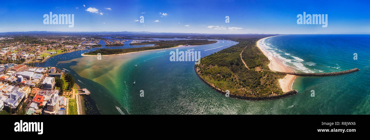 Panorama di Port Macquarie town waterfront lungo il Fiume Hastings entrando in oceano Pacifico intorno al capo piatto e la spiaggia di sabbia con un sacco di barche. Foto Stock