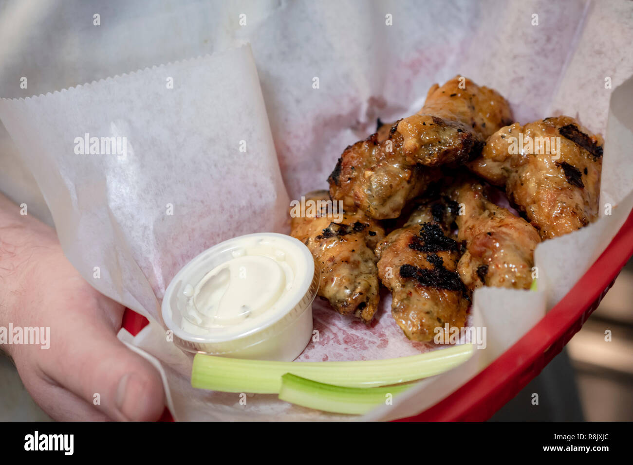 Cesto di ali di pollo con salsa di immersione e sedano. Solo a mano. Foto Stock