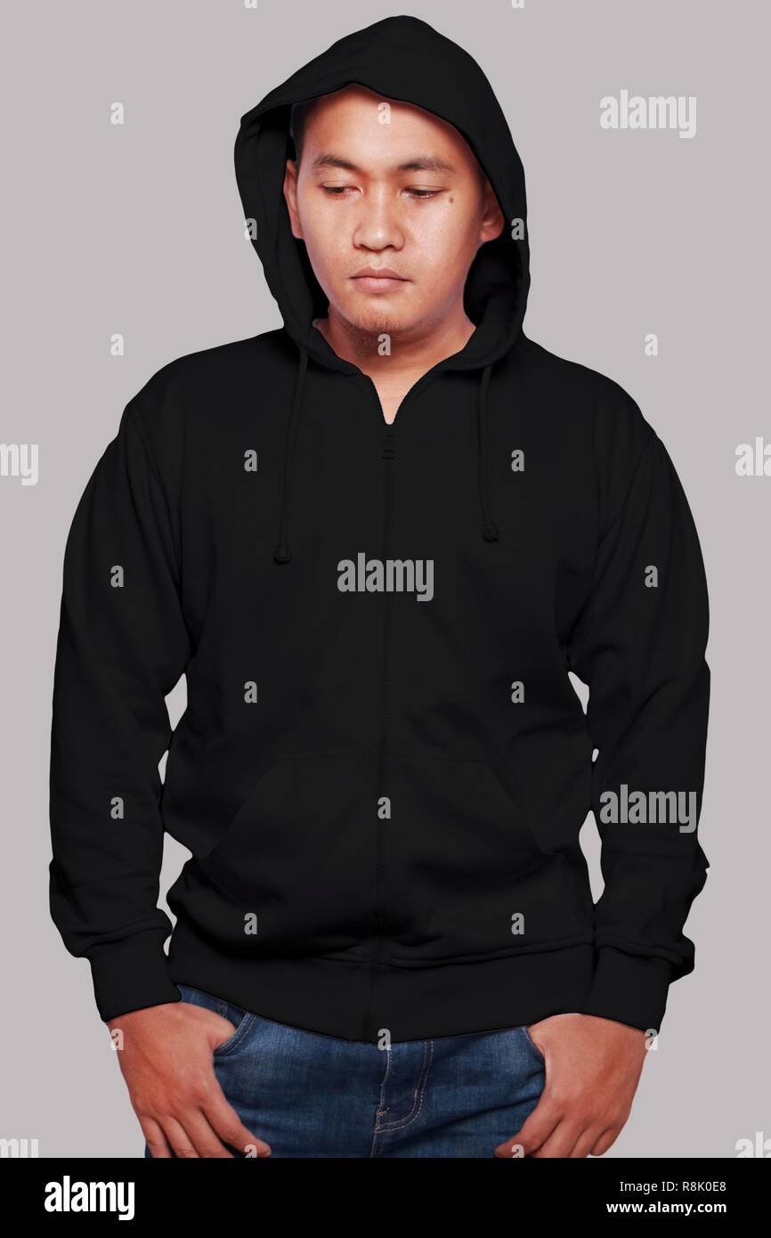 Felpa vuoto mock up, vista frontale, isolato su grigio. Asian maschio modello usura normale felpa con cappuccio nero mockup. Felpa con cappuccio design presentazione. Jumper per la stampa. Foto Stock