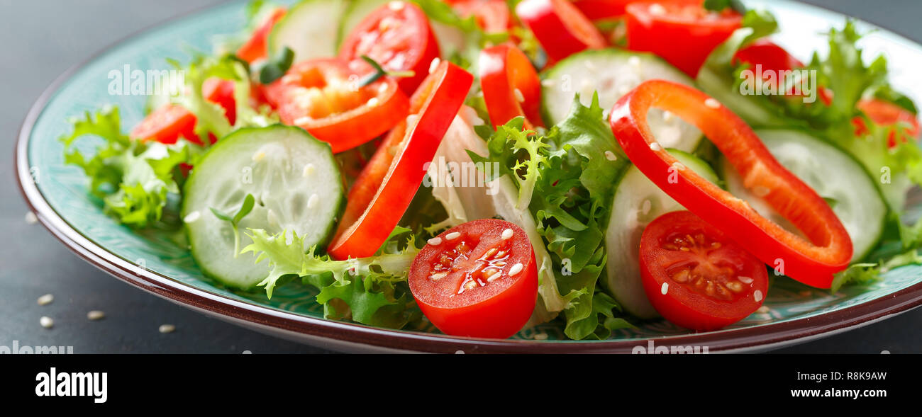 Sana vegetale vegetariano insalata di lattuga fresca, cetrioli, peperoni e pomodori. Impianto vegano-based food. Banner Foto Stock